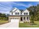 Charming two-story home featuring a stone facade, white siding, and a well-manicured front yard at 416 Longleaf Glen Ln, Zebulon, NC 27597