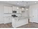 Well-lit kitchen featuring a marble island, stainless steel appliances, white cabinets, and hardwood floors at 416 Longleaf Glen Ln, Zebulon, NC 27597