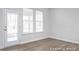 Bright living room with hardwood floors, large windows offering natural light, and a glass-paneled door at 416 Longleaf Glen Ln, Zebulon, NC 27597