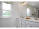 Bright bathroom featuring double vanity with white cabinets and a large mirror at 420 Longleaf Glen Ln, Zebulon, NC 27597