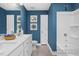 Blue bathroom featuring double vanity with white countertop and tiled shower at 420 Longleaf Glen Ln, Zebulon, NC 27597