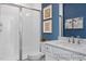 Contemporary bathroom featuring a white vanity, frameless shower, and a vibrant blue accent wall at 420 Longleaf Glen Ln, Zebulon, NC 27597