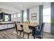Elegant dining room featuring modern decor, large windows with stylish curtains, and an adjacent living space at 420 Longleaf Glen Ln, Zebulon, NC 27597
