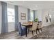Bright dining room featuring modern decor, large windows with stylish curtains, and a view of the entryway at 420 Longleaf Glen Ln, Zebulon, NC 27597
