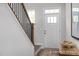 Bright entryway featuring hardwood floors, stairs with a dark wood banister, and a white front door at 420 Longleaf Glen Ln, Zebulon, NC 27597