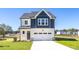 Charming two-story home featuring a crisp white garage door and a combination of white and navy blue siding at 420 Longleaf Glen Ln, Zebulon, NC 27597