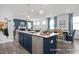 Bright kitchen with a large blue island featuring a sink, and a view extending to the living and dining areas at 420 Longleaf Glen Ln, Zebulon, NC 27597