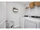 Cozy laundry room featuring white appliances, overhead storage, and stylish patterned floor tiles at 420 Longleaf Glen Ln, Zebulon, NC 27597