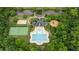 A beautiful aerial view of community pool, tennis court, volleyball court, and playground amidst lush greenery at 513 Heswall Ct, Rolesville, NC 27571
