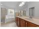 Bright bathroom featuring a double vanity, soaking tub, and separate glass-enclosed shower at 513 Heswall Ct, Rolesville, NC 27571