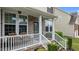 Inviting covered front porch with white railings and brick accents at 513 Heswall Ct, Rolesville, NC 27571