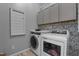 Well-equipped laundry room with washer, dryer, and upper cabinets at 513 Heswall Ct, Rolesville, NC 27571