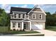 Charming two-story home with gray siding, white trim, a covered porch, and an attached two-car garage at 549 Contempo Ct # 6, Rolesville, NC 27571