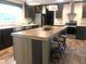 Modern kitchen features a spacious island with seating, stainless steel appliances, and stylish pendant lighting at 550 Saplin Branch Rd, Timberlake, NC 27583