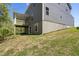 View of the home's back exterior from the yard, showing the basement walkout and an elevated deck at 569 Freedom Trail Dr, Willow Springs, NC 27592