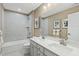 Bright bathroom with a double sink vanity, a full tub, white tile and modern fixtures at 569 Freedom Trail Dr, Willow Springs, NC 27592