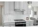 Close up of the stainless steel gas range with a modern backsplash and modern stainless vent hood at 569 Freedom Trail Dr, Willow Springs, NC 27592