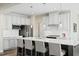 Kitchen island with modern cabinets, stainless appliances and barstool seating under modern pendant lights at 569 Freedom Trail Dr, Willow Springs, NC 27592