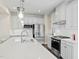 Modern kitchen with white cabinets, stainless steel appliances, and a herringbone backsplash offers a sleek design at 569 Freedom Trail Dr, Willow Springs, NC 27592
