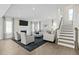 Spacious living room with a fireplace, neutral decor, and staircase access to the upper level at 569 Freedom Trail Dr, Willow Springs, NC 27592