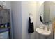 Bathroom with a pedestal sink, a round mirror, and a cabinet for optimal storage at 633 Longstanton Ave, Zebulon, NC 27597