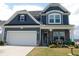 Charming two-story home featuring a two-car garage, stone accents, and landscaped front yard at 633 Longstanton Ave, Zebulon, NC 27597