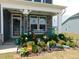 Inviting front porch with stone accents, lush landscaping, and a welcoming entrance at 633 Longstanton Ave, Zebulon, NC 27597