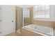 Luxurious bathroom featuring a soaking tub, glass shower, and natural light at 704 Valleywater St, Fuquay Varina, NC 27526