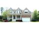 Charming two-story home featuring blue shutters, a covered porch, and an attached two-car garage at 704 Valleywater St, Fuquay Varina, NC 27526