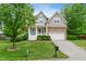 Charming home with a stone-accented facade, manicured lawn, and a welcoming blue front door at 704 Valleywater St, Fuquay Varina, NC 27526