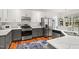 A bright kitchen features stainless appliances, white cabinets, and wooden floors covered by an area rug at 704 Valleywater St, Fuquay Varina, NC 27526