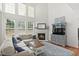 Sun-filled living room with a fireplace, large windows, and cozy seating, ideal for relaxation at 704 Valleywater St, Fuquay Varina, NC 27526