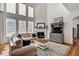 Bright living room boasting high ceilings, fireplace, large windows, and hardwood flooring at 704 Valleywater St, Fuquay Varina, NC 27526