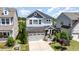 Beautiful two-story home with stone accents, an attached garage, and well-manicured landscaping at 79 Tarwick Ave, Chapel Hill, NC 27516