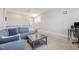 Cozy living room features a plush blue sofa, coffee table, and neutral carpeting at 79 Tarwick Ave, Chapel Hill, NC 27516