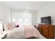 Bright bedroom with a large window, comfortable bed, and classic wooden dresser at 810 Maple Berry Ln # 104, Raleigh, NC 27607
