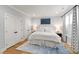 Bright bedroom with wood flooring, a patterned rug, bed with white bedding, and dual closets at 810 Maple Berry Ln # 104, Raleigh, NC 27607
