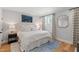 Bedroom features a bed with white linens, wood floors, and a blue area rug at 810 Maple Berry Ln # 104, Raleigh, NC 27607