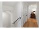Hallway with hardwood floors, white walls, and a staircase, leading to other areas of the home at 810 Maple Berry Ln # 104, Raleigh, NC 27607
