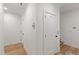 Bright hallway with hardwood floors, white walls, and doors, providing access to different areas at 810 Maple Berry Ln # 104, Raleigh, NC 27607