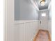 Inviting hallway with white wainscoting, light gray paint, and a patterned rug at 810 Maple Berry Ln # 104, Raleigh, NC 27607
