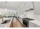 Bright kitchen with white cabinets, stainless steel appliances, and a view into the adjacent living area at 810 Maple Berry Ln # 104, Raleigh, NC 27607