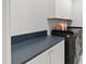 Laundry room features modern washer and dryer with dark countertops and white cabinets at 810 Maple Berry Ln # 104, Raleigh, NC 27607