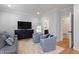 Living room with light blue chairs, sofa with pillows, and hardwood floors at 810 Maple Berry Ln # 104, Raleigh, NC 27607