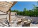 Outdoor patio area with two chairs, a small table, wooden pergola, and serene surrounding trees at 810 Maple Berry Ln # 104, Raleigh, NC 27607