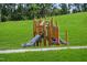 Charming neighborhood playground with climbing structure and slides for outdoor fun, nestled in a grassy, wooded area at 909 Crossbill Dr, Knightdale, NC 27545