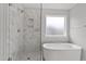 Sleek bathroom featuring a glass shower, soaking tub, and frosted window at 95 Black Walnut Dr # 191, Garner, NC 27529