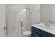 Bathroom featuring a tiled shower with glass door, quartz countertop, and a dark-colored vanity at 95 Black Walnut Dr # 191, Garner, NC 27529