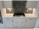 Close up of stainless gas cooktop with white cabinets, stone backsplash and bronze hardware at 95 Black Walnut Dr # 191, Garner, NC 27529