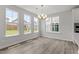 Bright dining room featuring wood floors, a modern chandelier, and large windows providing natural light at 95 Black Walnut Dr # 191, Garner, NC 27529